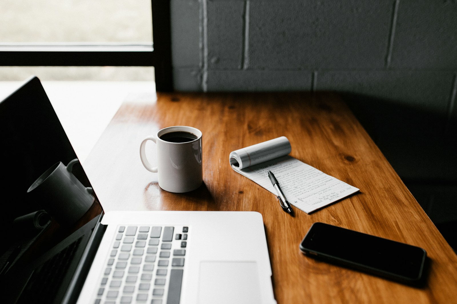 Laptop, notebook and coffee on a workspace for independent learning